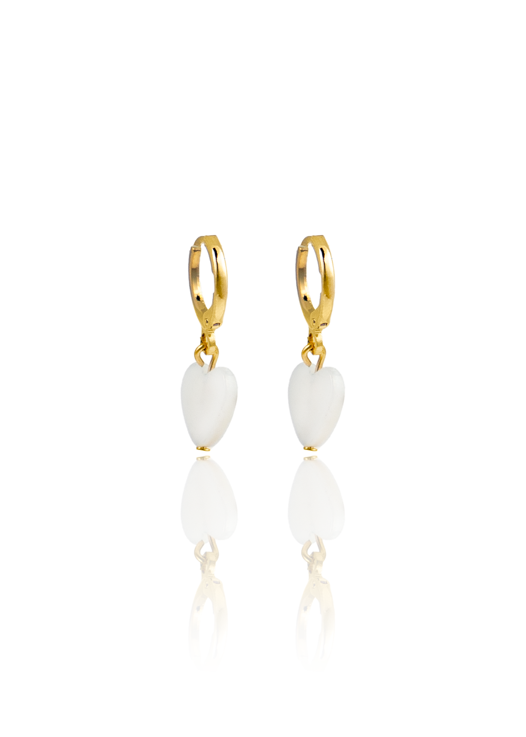 A pair of gold hoop earrings features dangling white heart-shaped charms against a clean white background.