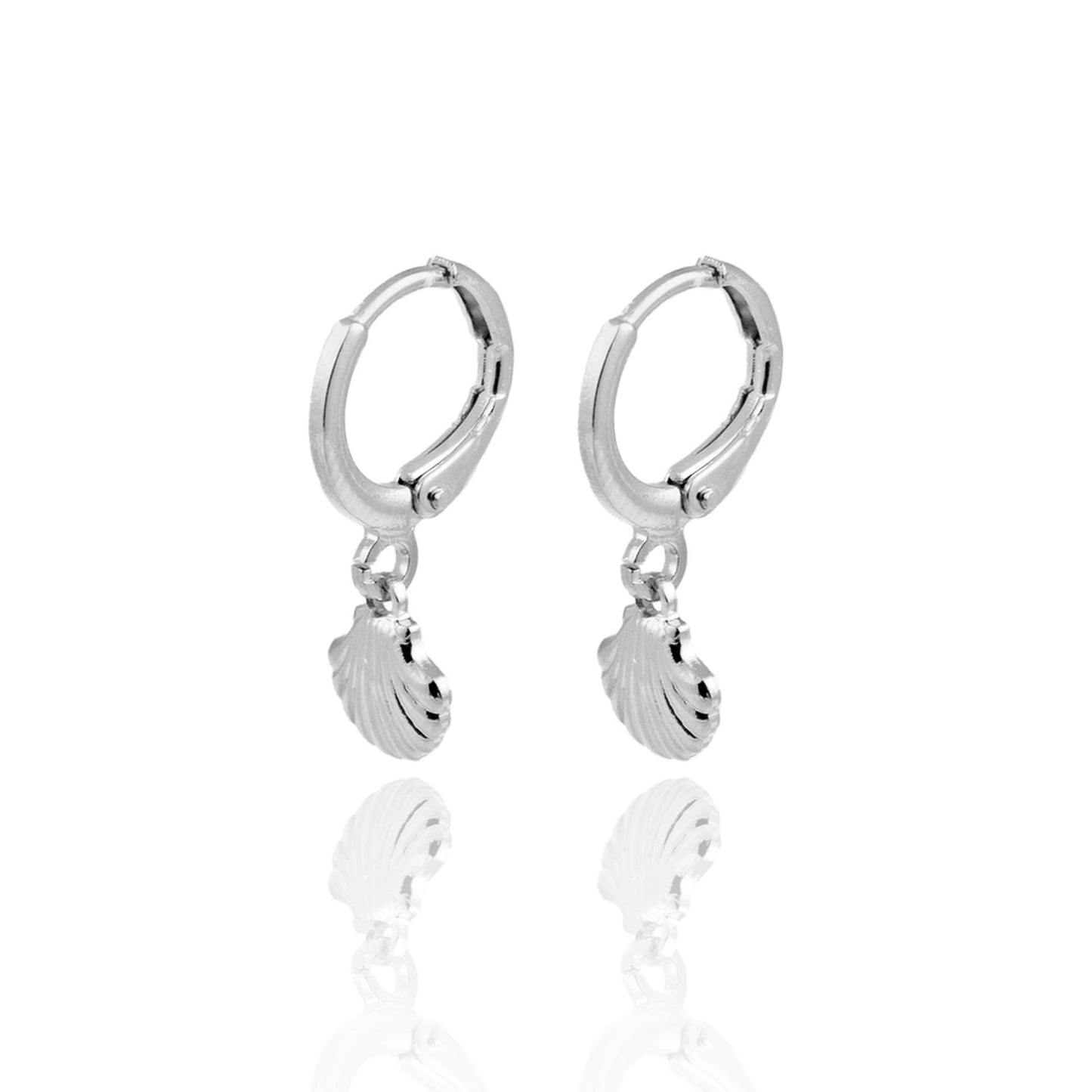 A pair of silver hoop earrings featuring dangling seashell charms displayed against a white background with a subtle reflection.
