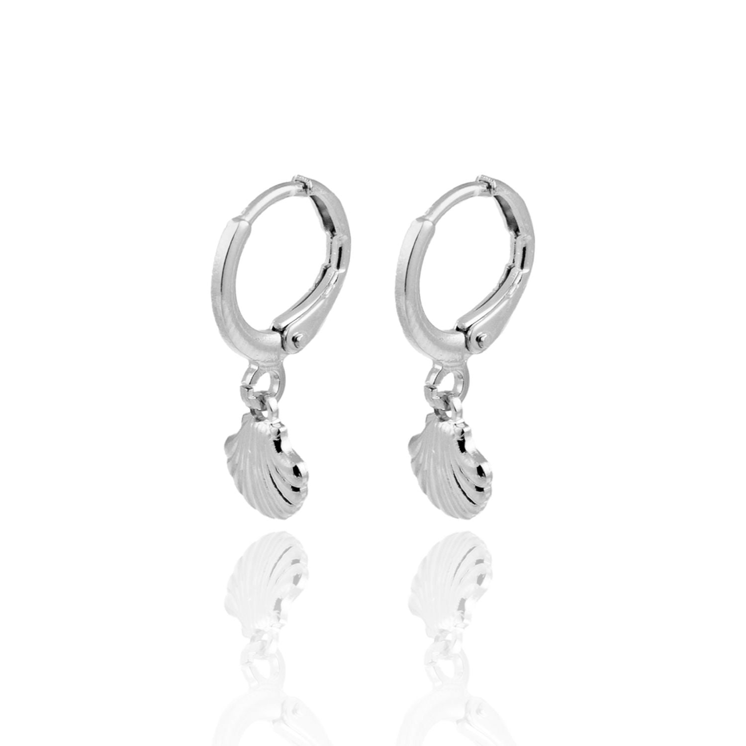 A pair of silver hoop earrings featuring dangling seashell charms displayed against a white background with a subtle reflection.