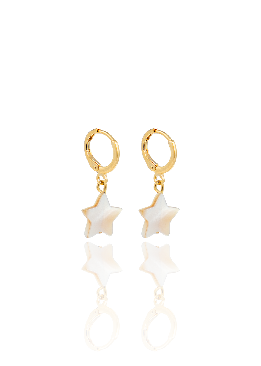 A pair of gold huggie hoop earrings features hanging mother-of-pearl star charms against a clean white background.