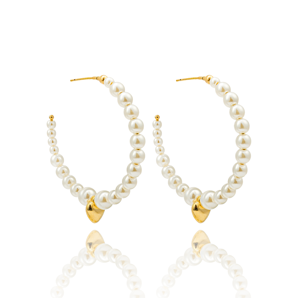 A pair of elegant gold hoop earrings features a delicate arrangement of white faux pearls and a small hanging gold heart charm against a clean white background.