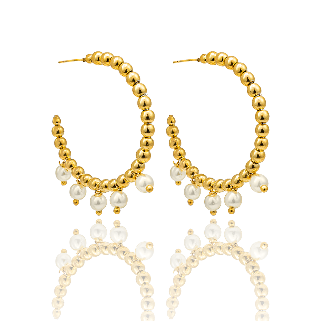 A pair of gold beaded hoop earrings featuring hanging white pearls sits against a white background with a soft reflection below.