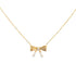 A delicate gold bow pendant necklace featuring a sparkling center diamond hangs against a clean white background.
