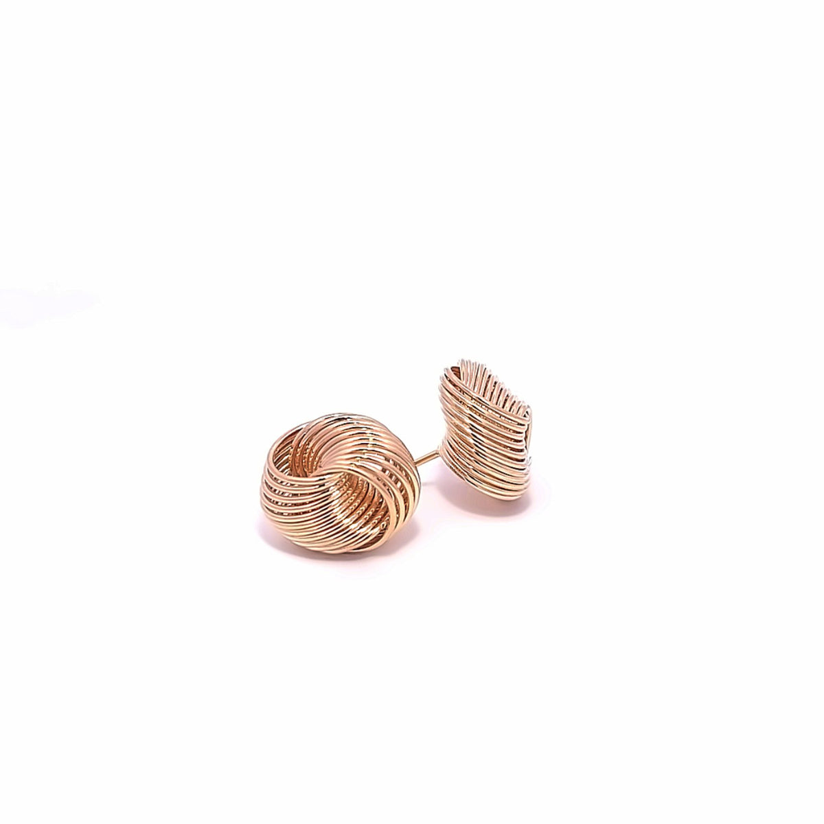 A pair of gold wire-wrapped knot stud earrings rests on a clean white surface.