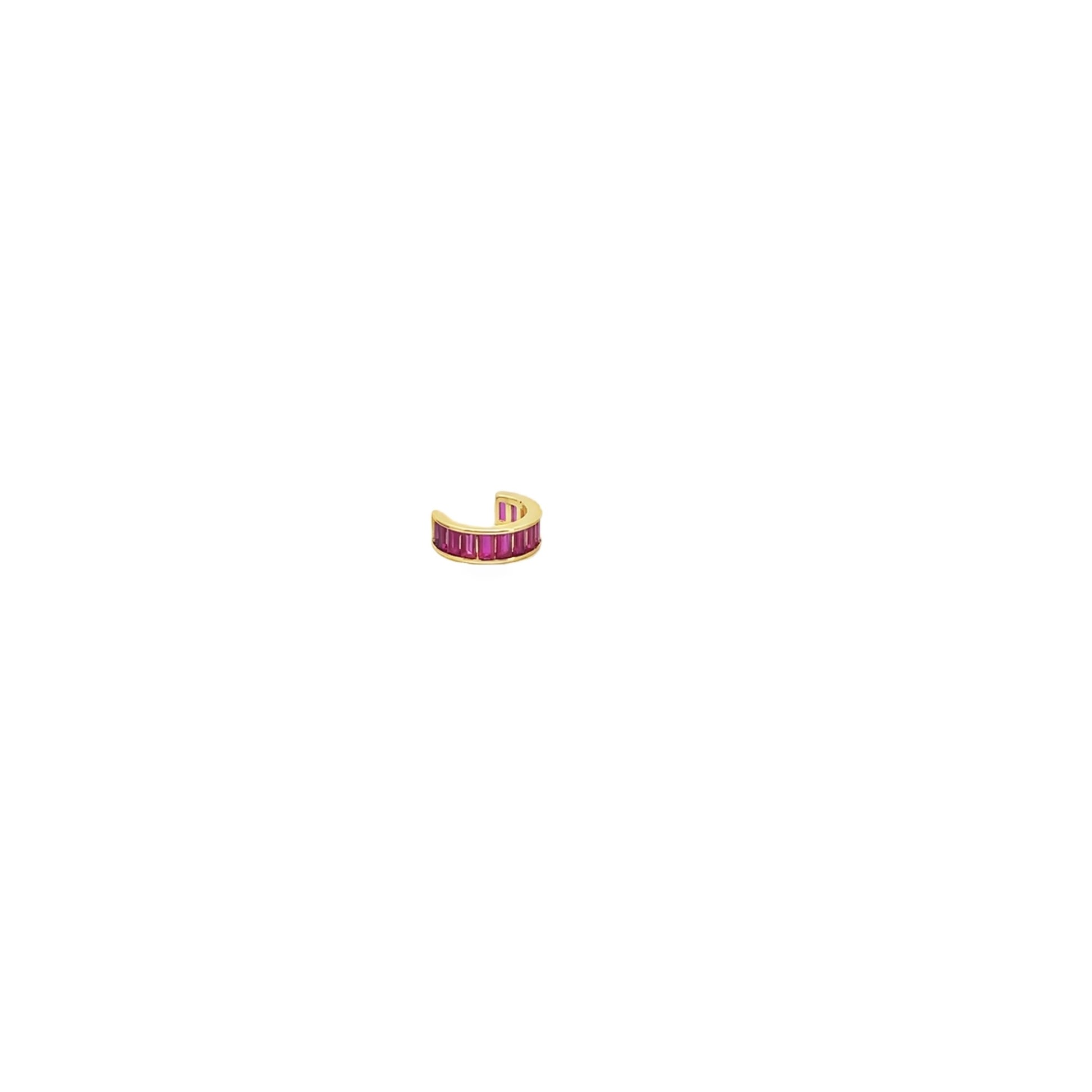 A gold ear cuff features a vibrant row of rectangular pink gemstones against a clean white background.