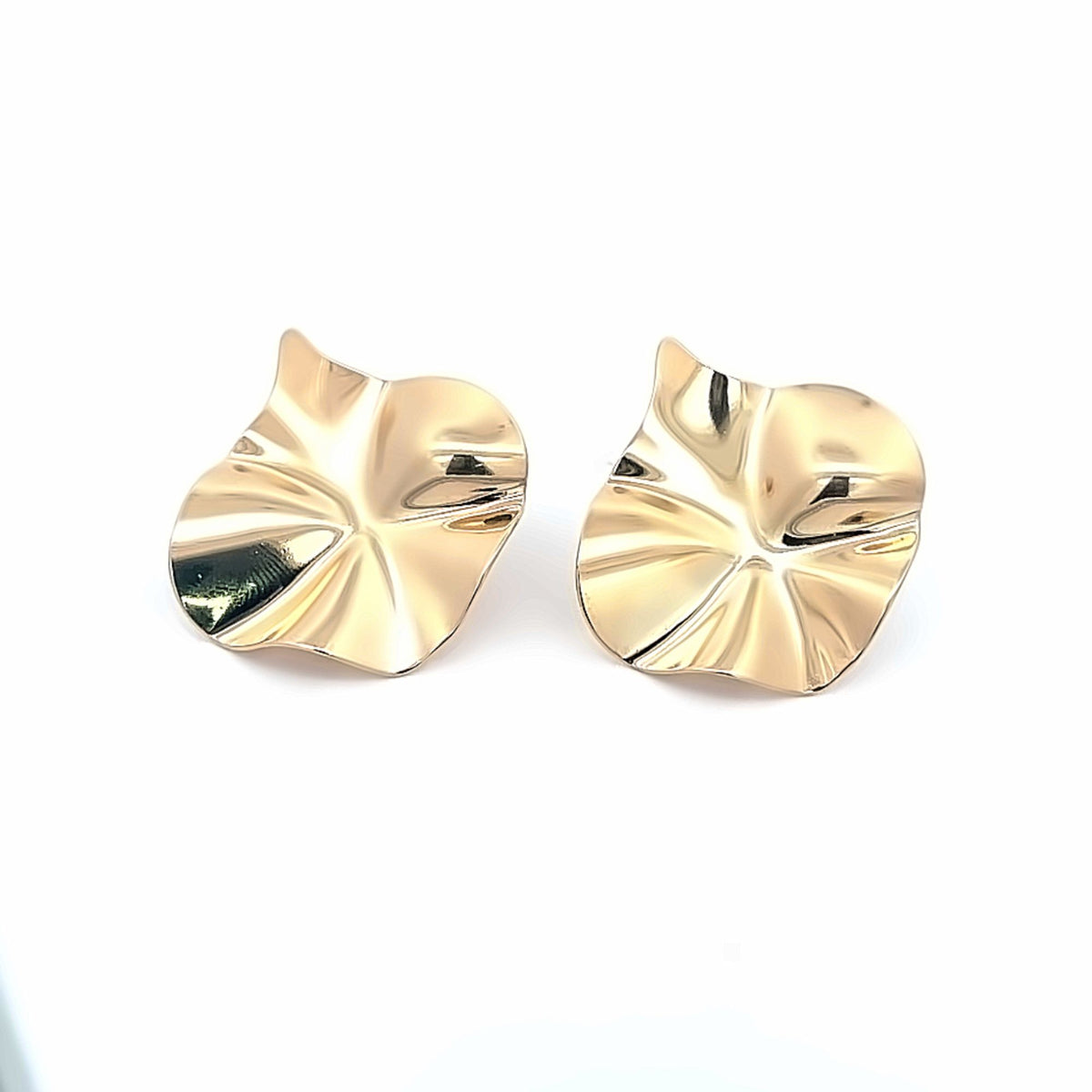 A pair of shiny gold abstract statement earrings rests against a clean white background.