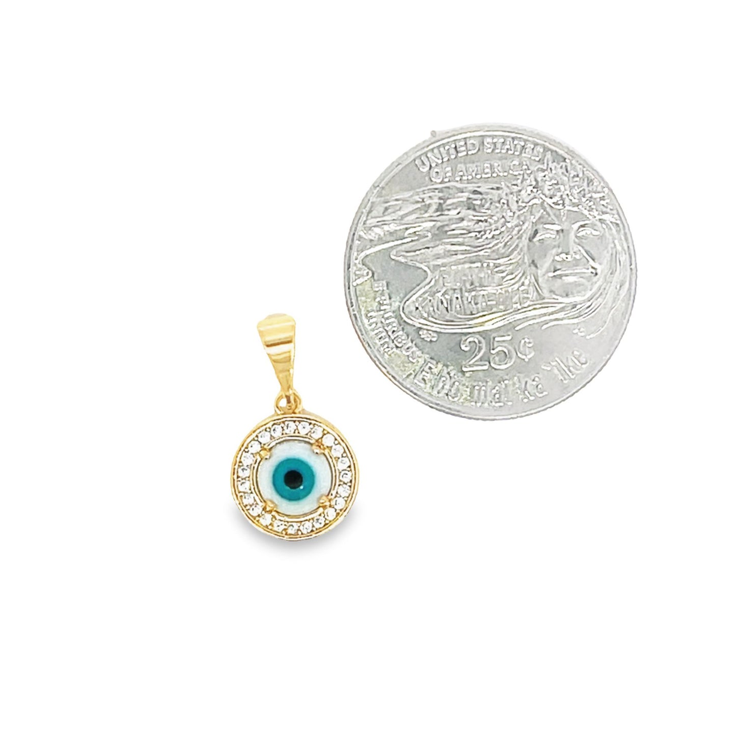 A gold evil eye pendant featuring sparkling cubic zirconia stones rests next to a US quarter coin for scale.