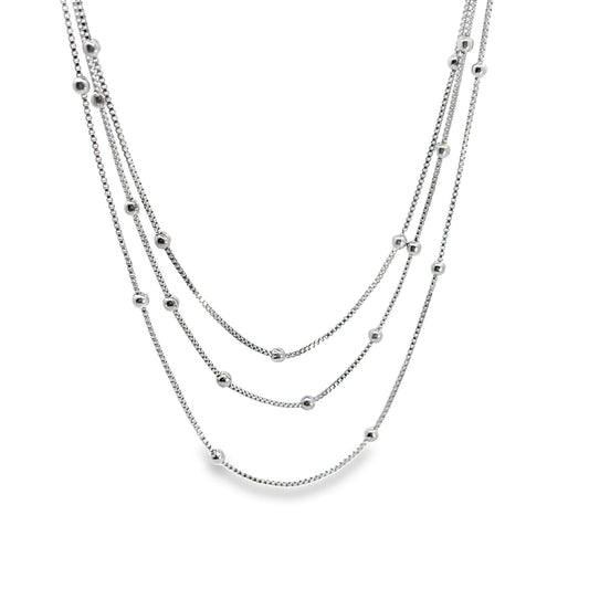 A delicate multi-strand silver necklace features dangling spherical beads along each dainty chain.