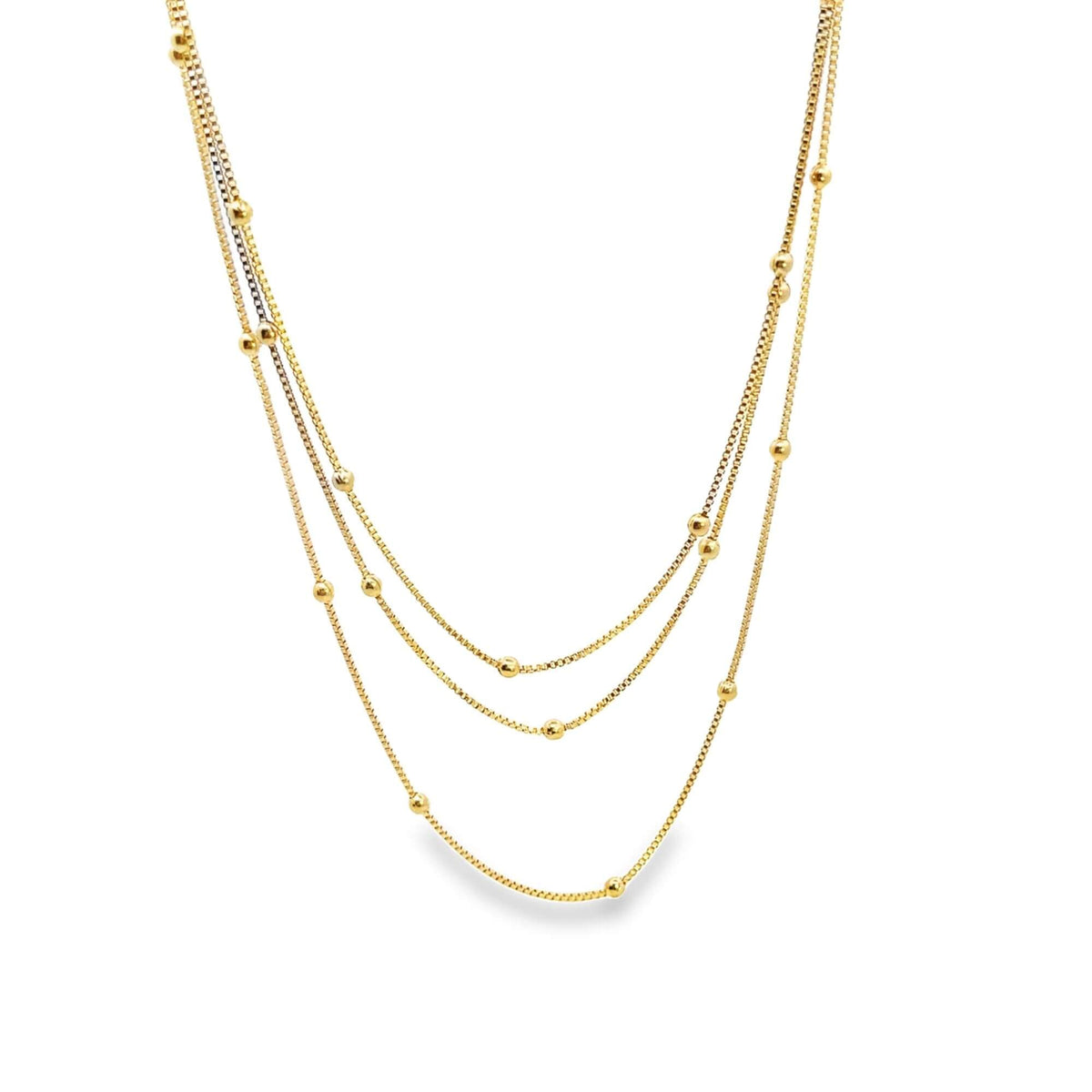 A delicate gold multi-strand layered necklace features sparkling box chains embellished with tiny, evenly spaced gold beads.