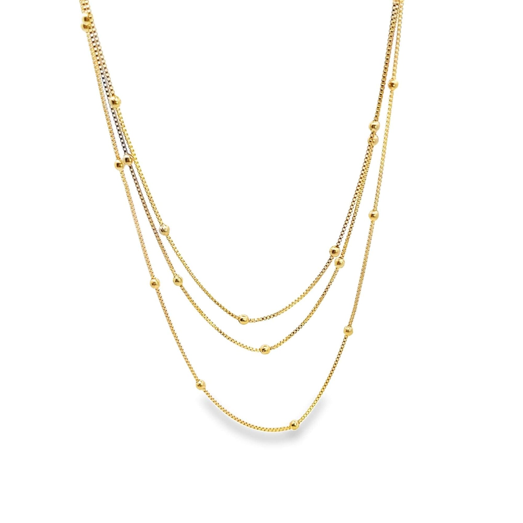 A delicate gold multi-strand layered necklace features sparkling box chains embellished with tiny, evenly spaced gold beads.