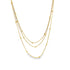 A delicate gold multi-strand layered necklace features sparkling box chains embellished with tiny, evenly spaced gold beads.