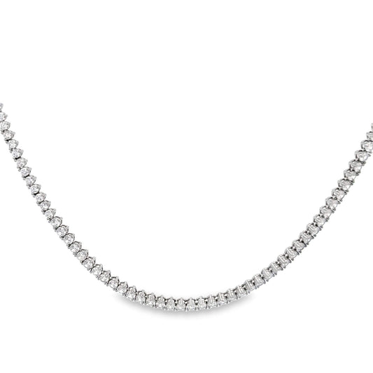 A sparkling diamond tennis necklace drapes in a graceful curve against a clean white background.
