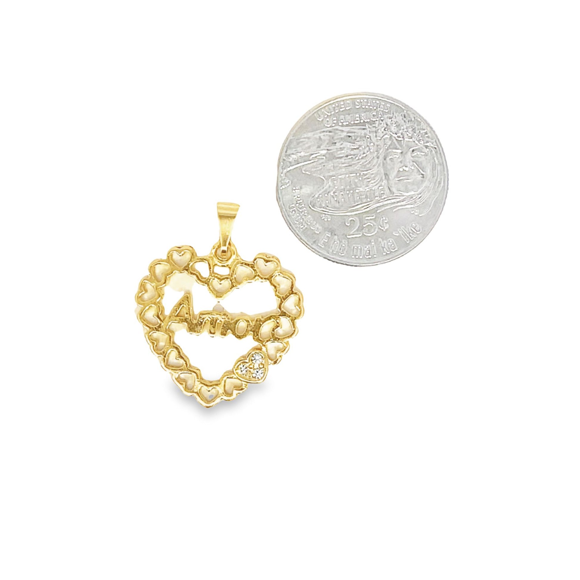 A gold heart pendant featuring the word "Amor" rests next to a quarter for size comparison.
