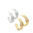 A pair of silver and a pair of gold textured half-hoop earrings rest on a white background.