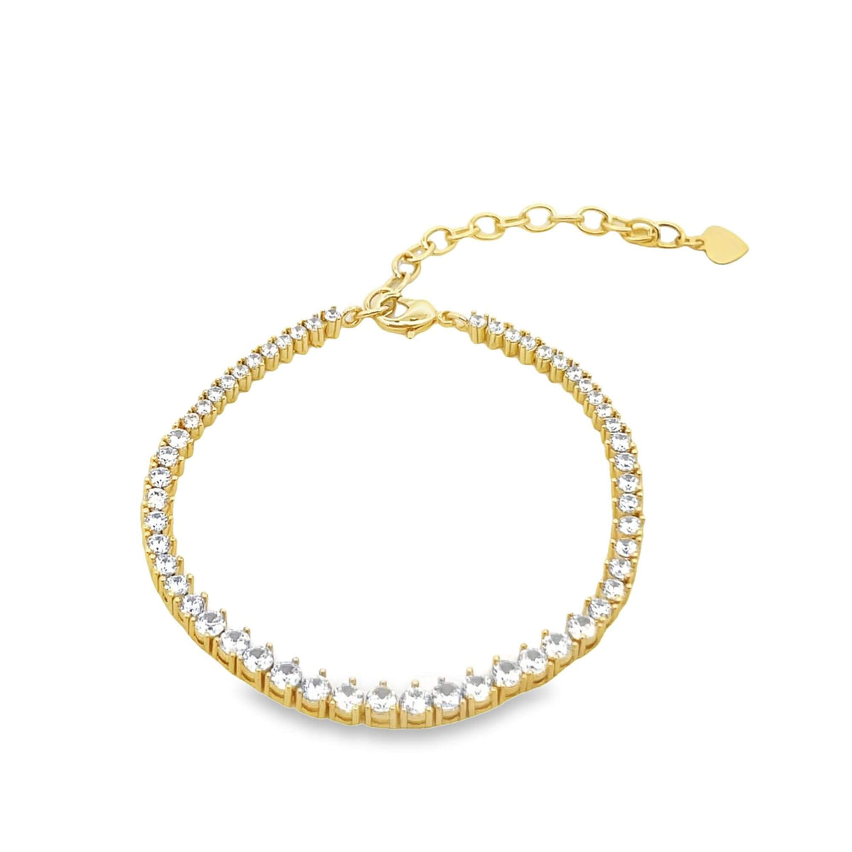 A delicate gold tennis bracelet features a continuous line of sparkling cubic zirconia stones and an adjustable chain ending in a tiny heart charm.