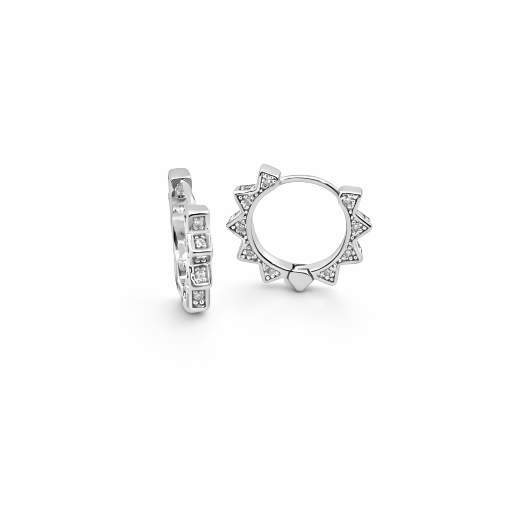 A pair of sterling silver huggie hoop earrings featuring a sparkling sunburst design with embedded cubic zirconia stones displays against a clean white background.