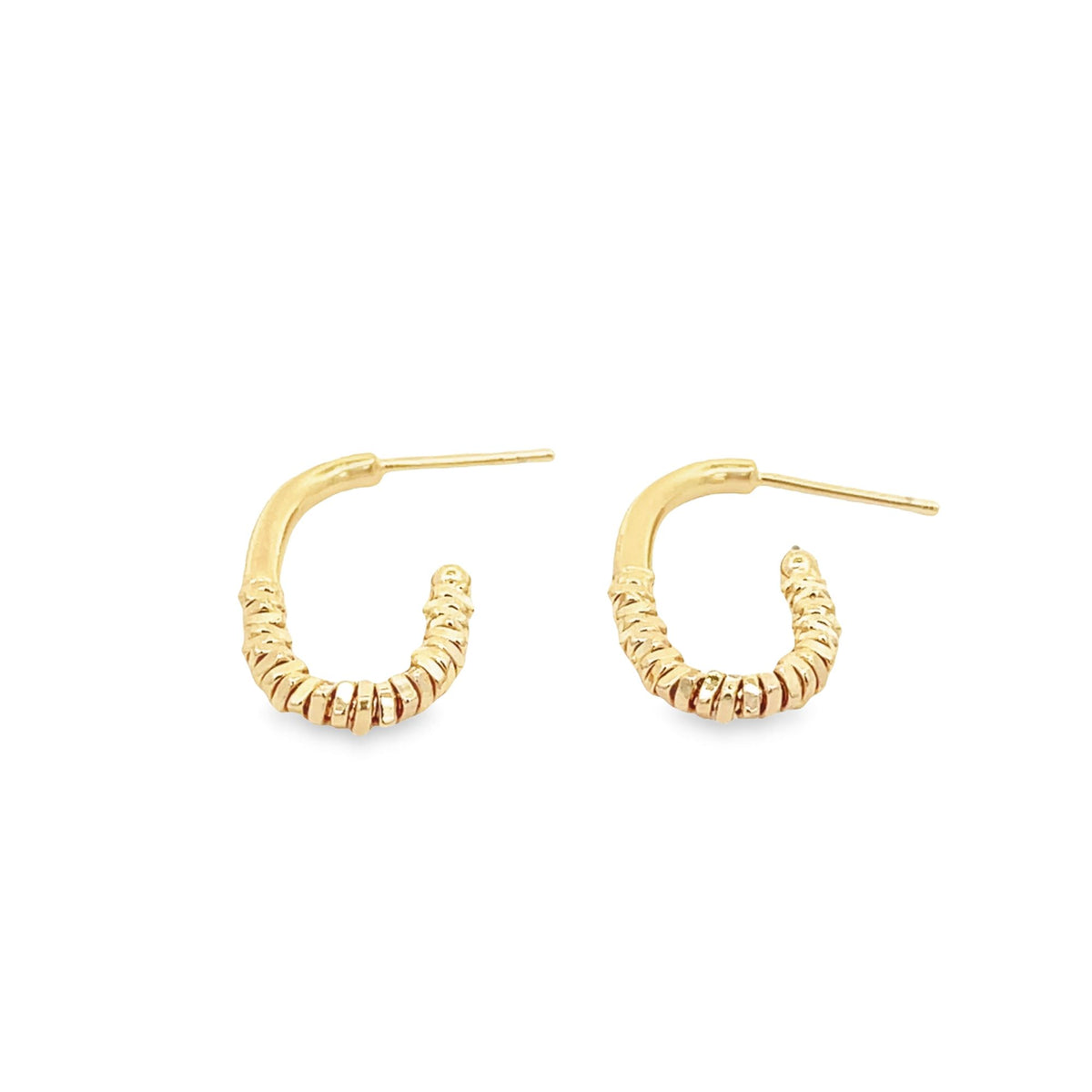 A pair of gold huggie hoop earrings featuring a textured, ribbed design rests against a clean white background.