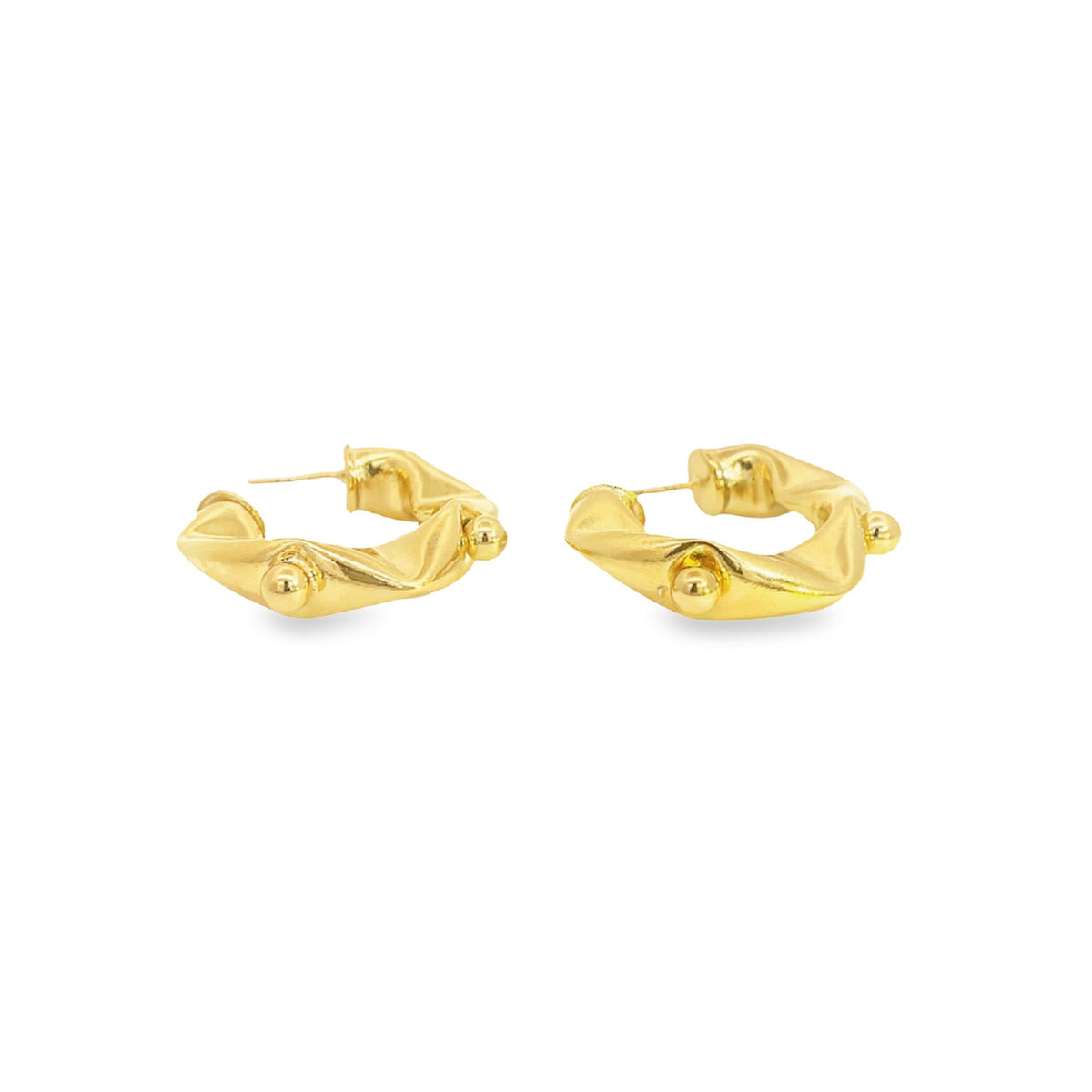 A pair of chunky gold hoop earrings with a twisted design and small ball details rests against a clean white background.