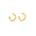 A pair of sculptural gold hoop earrings with textured faceted details rests on a white background.