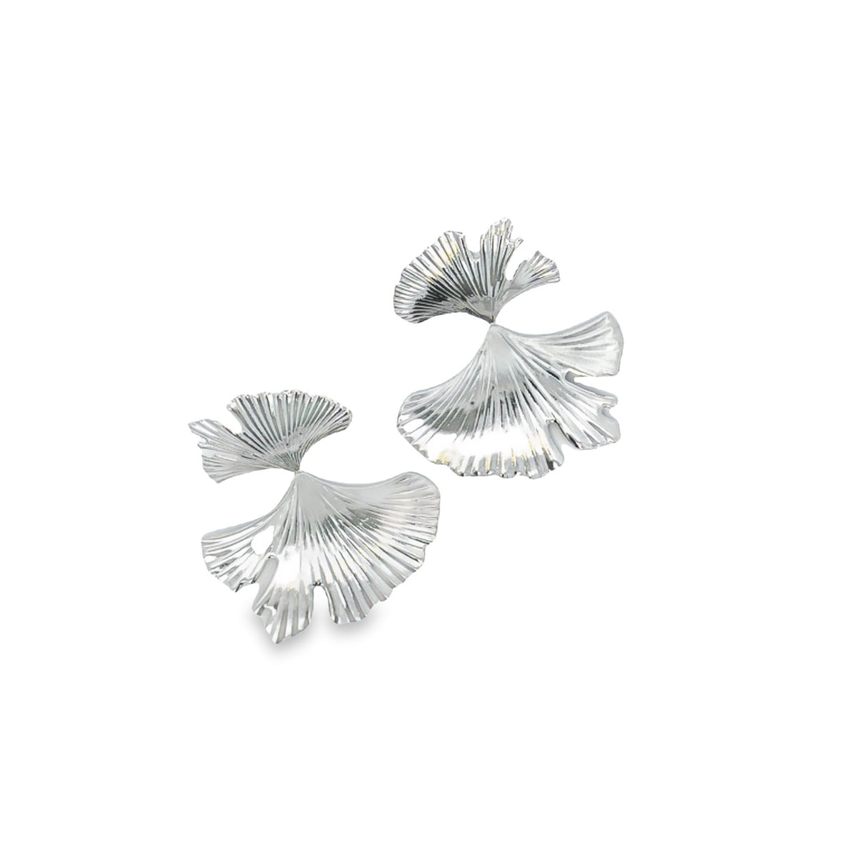 A pair of shiny silver earrings shaped like ginkgo leaves rests on a plain white background.