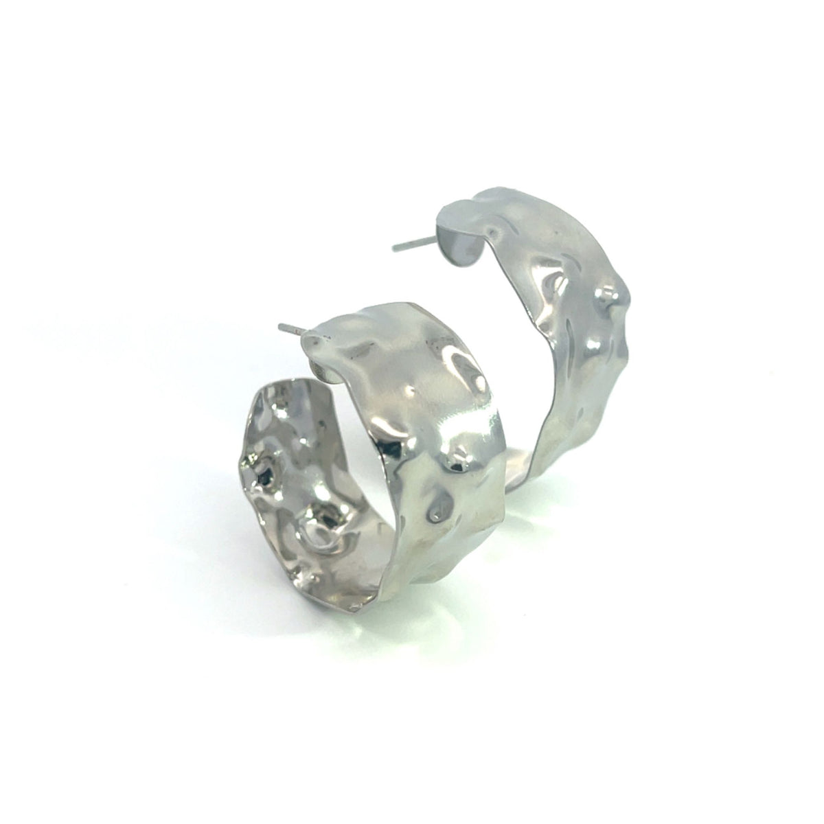 A pair of shiny silver hoop earrings featuring a unique hammered and melted texture rests on a white background.