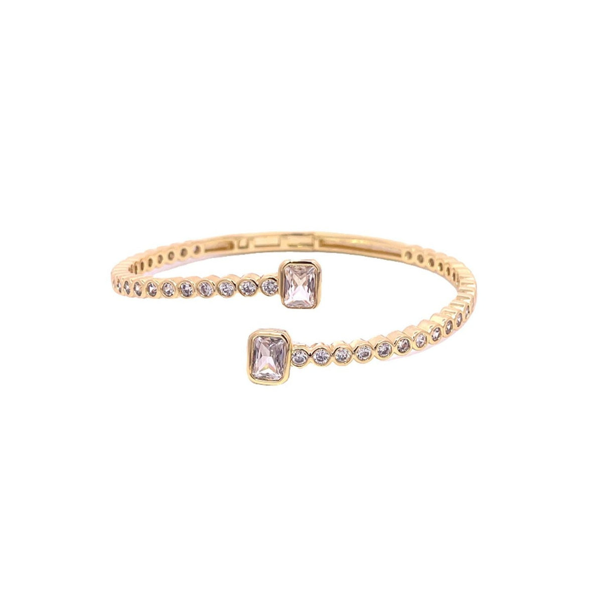 A gold cuff bracelet showcases alternating round diamonds and two prominent emerald-cut stones at its open ends.