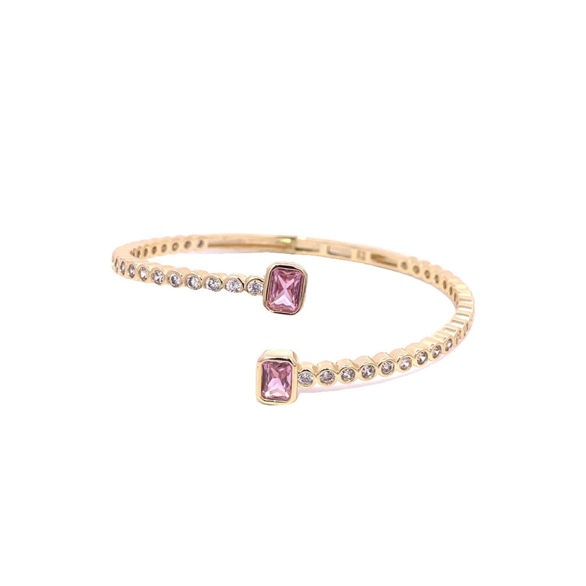 A gold bypass cuff bracelet features two emerald-cut pink stones at each open end, flanked by glittering bezel-set crystals.