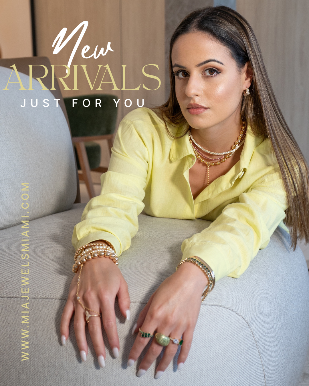 A woman reclining on a light gray sofa wearing a pale yellow button-up shirt and layered gold jewelry, with large overlaid text reading 'New ARRIVALS JUST FOR YOU' and a website URL along the left side.