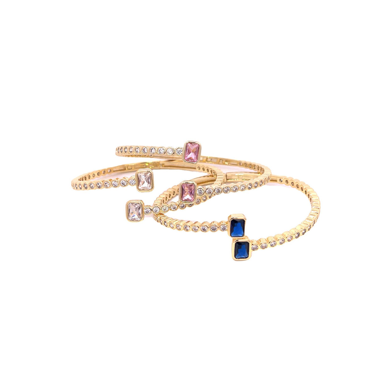 Three interlocking gold cuff bracelets feature sparkling cubic zirconia stones and colorful emerald-cut gemstones.