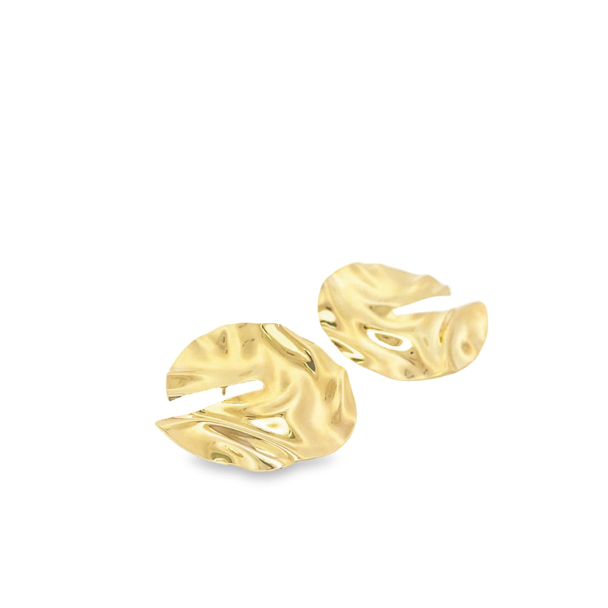 A pair of gold abstract hammered disc earrings rests against a white background.