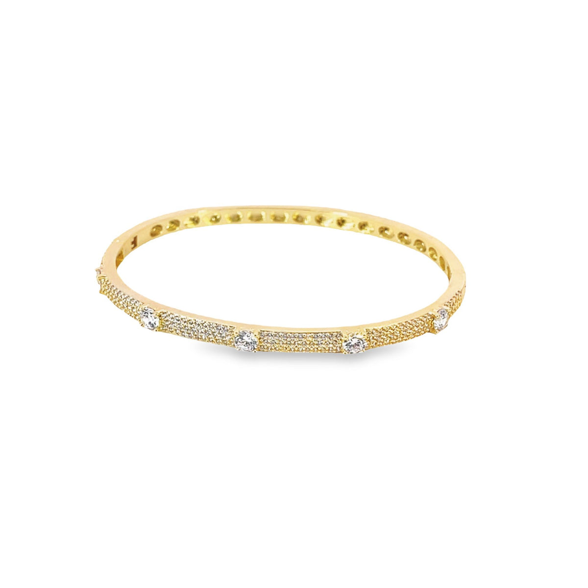 A diamond-studded gold bangle rests against a plain white background.