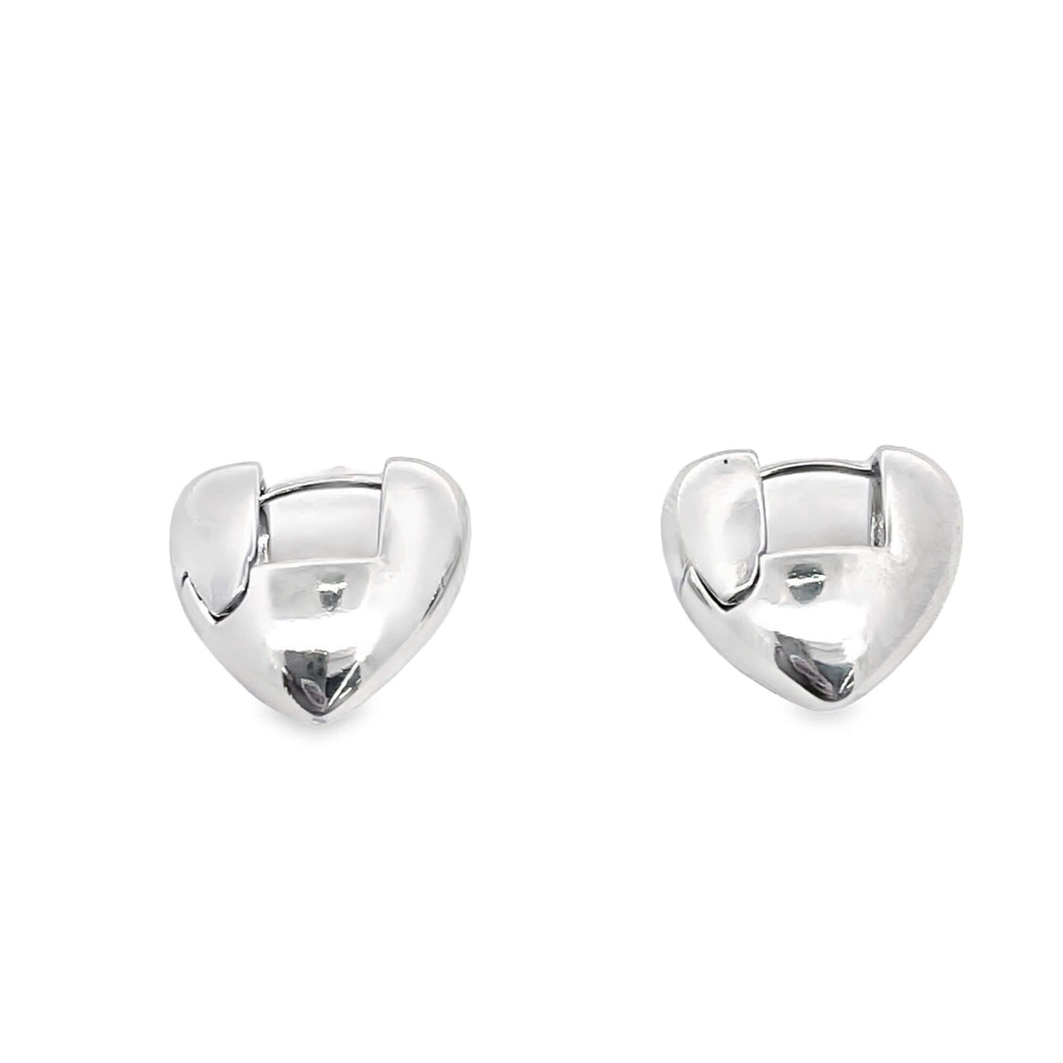 A pair of polished silver heart-shaped huggie hoop earrings gleam against a clean white background.