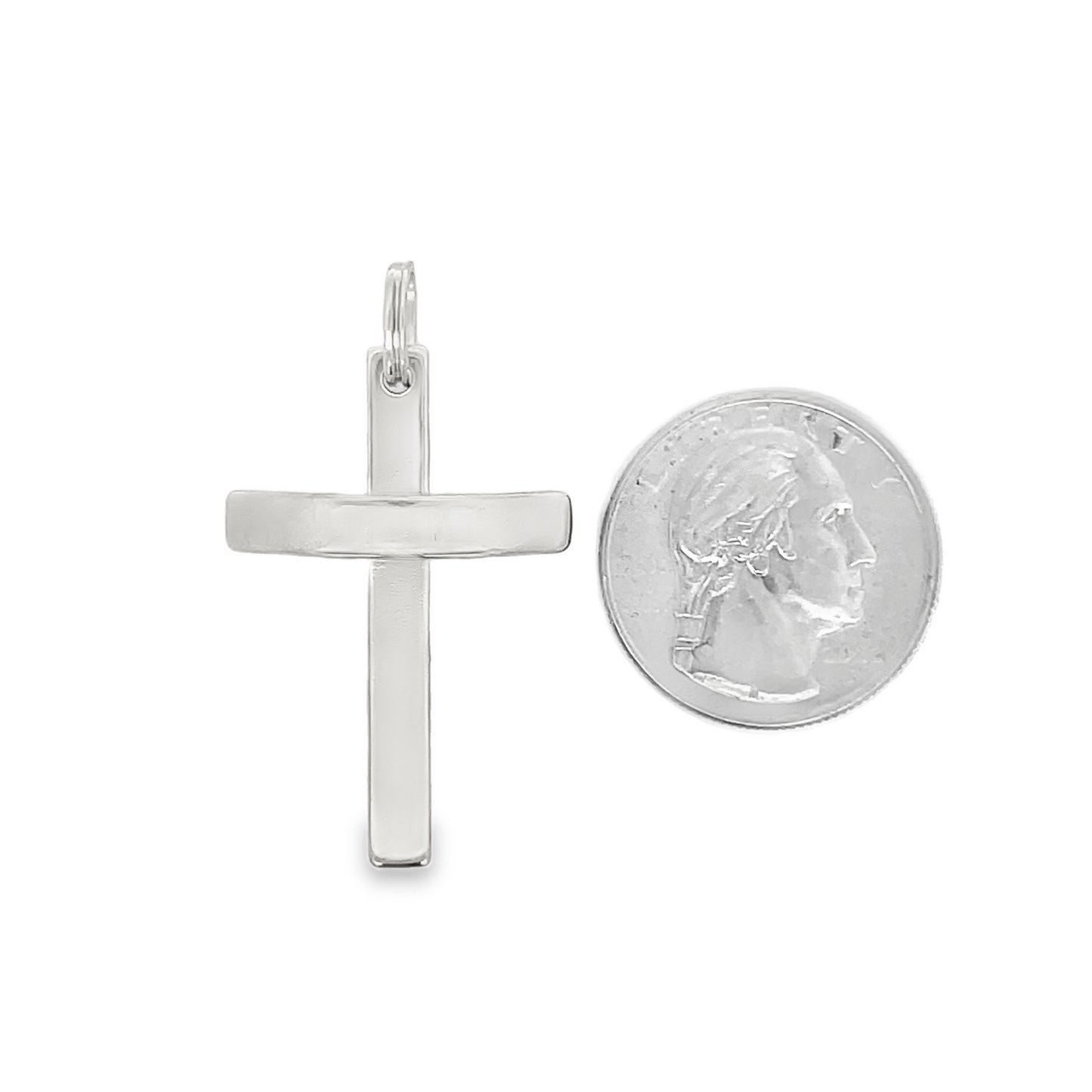 A sleek silver cross pendant is displayed next to a US quarter coin for size comparison.