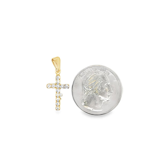 A gold cross pendant encrusted with sparkling diamonds rests next to a quarter coin for size comparison on a white background.