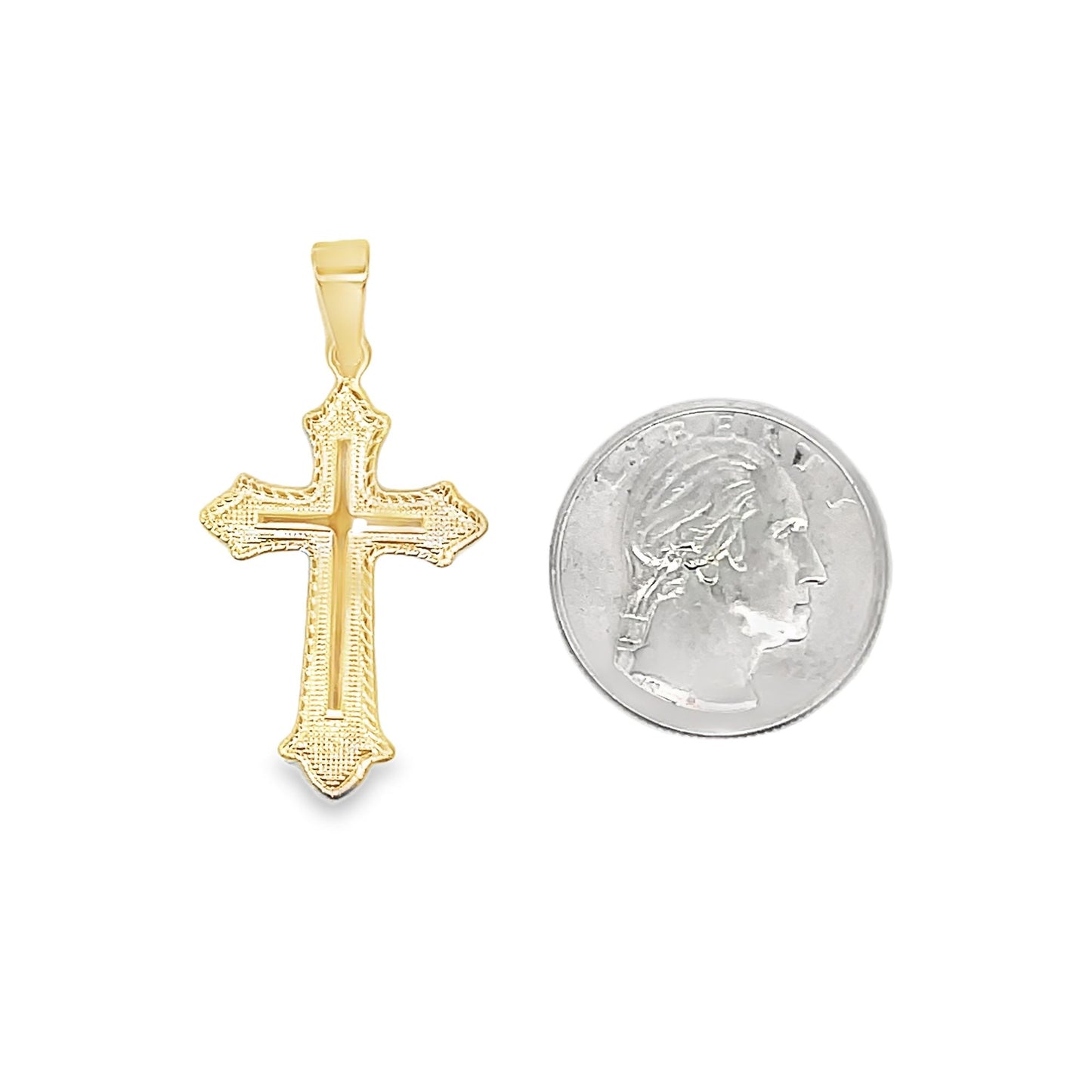 An ornate gold cross pendant rests beside a US quarter for scale.