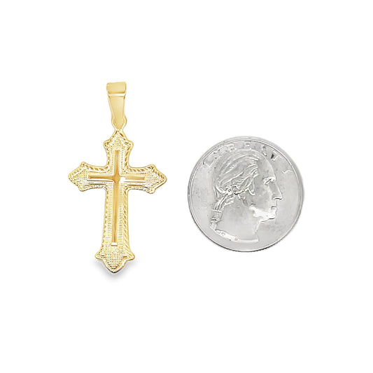 An ornate gold cross pendant rests beside a US quarter for scale.