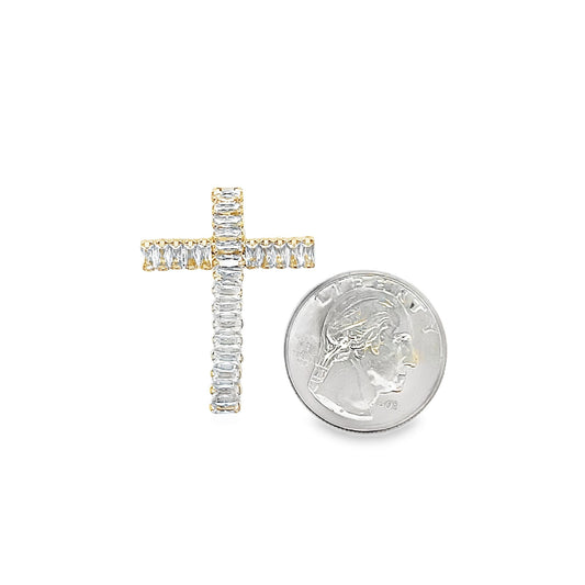 A gold diamond cross pendant rests next to a US quarter coin to show its scale.