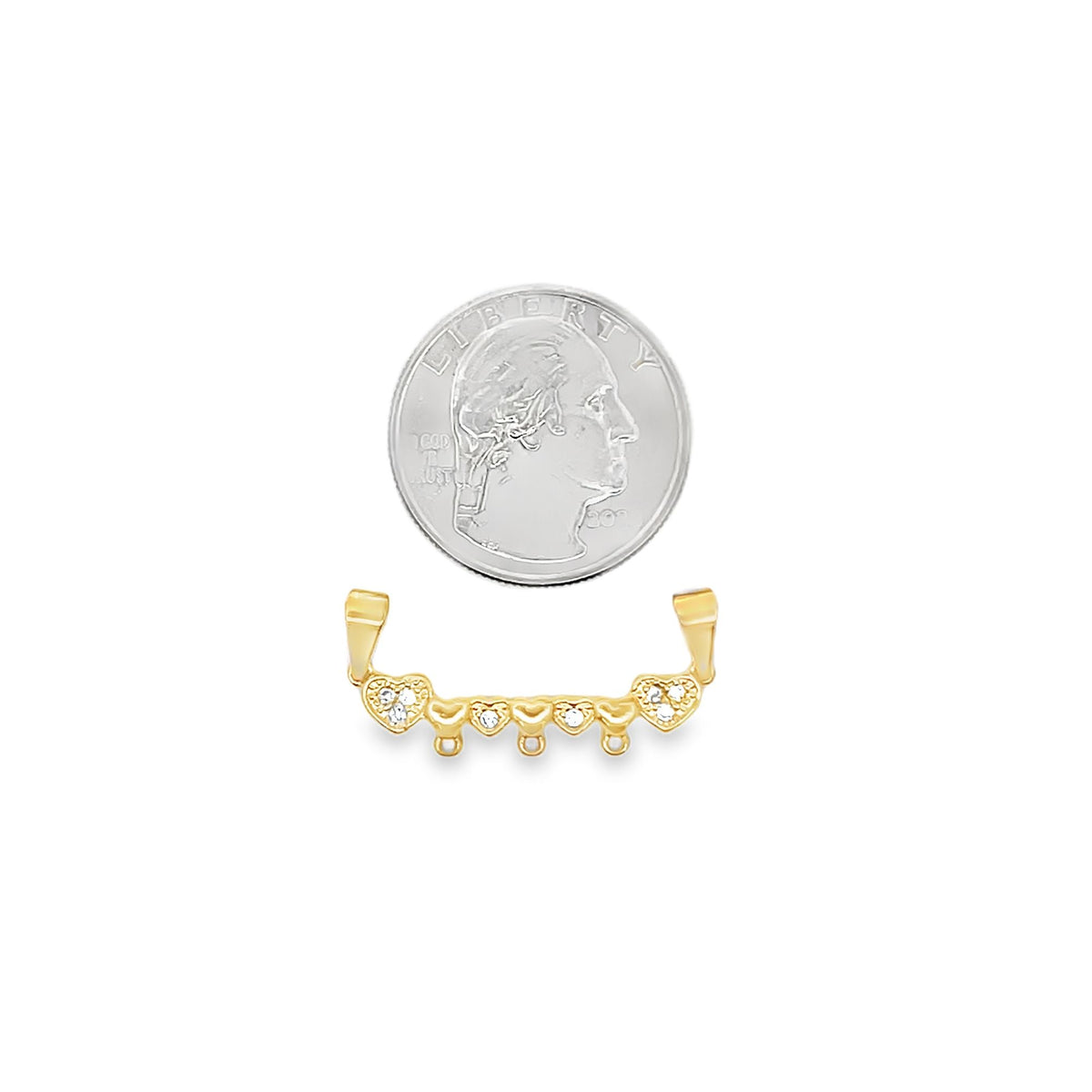 A delicate gold heart enhancer bail rests next to a US quarter coin to showcase its compact size.