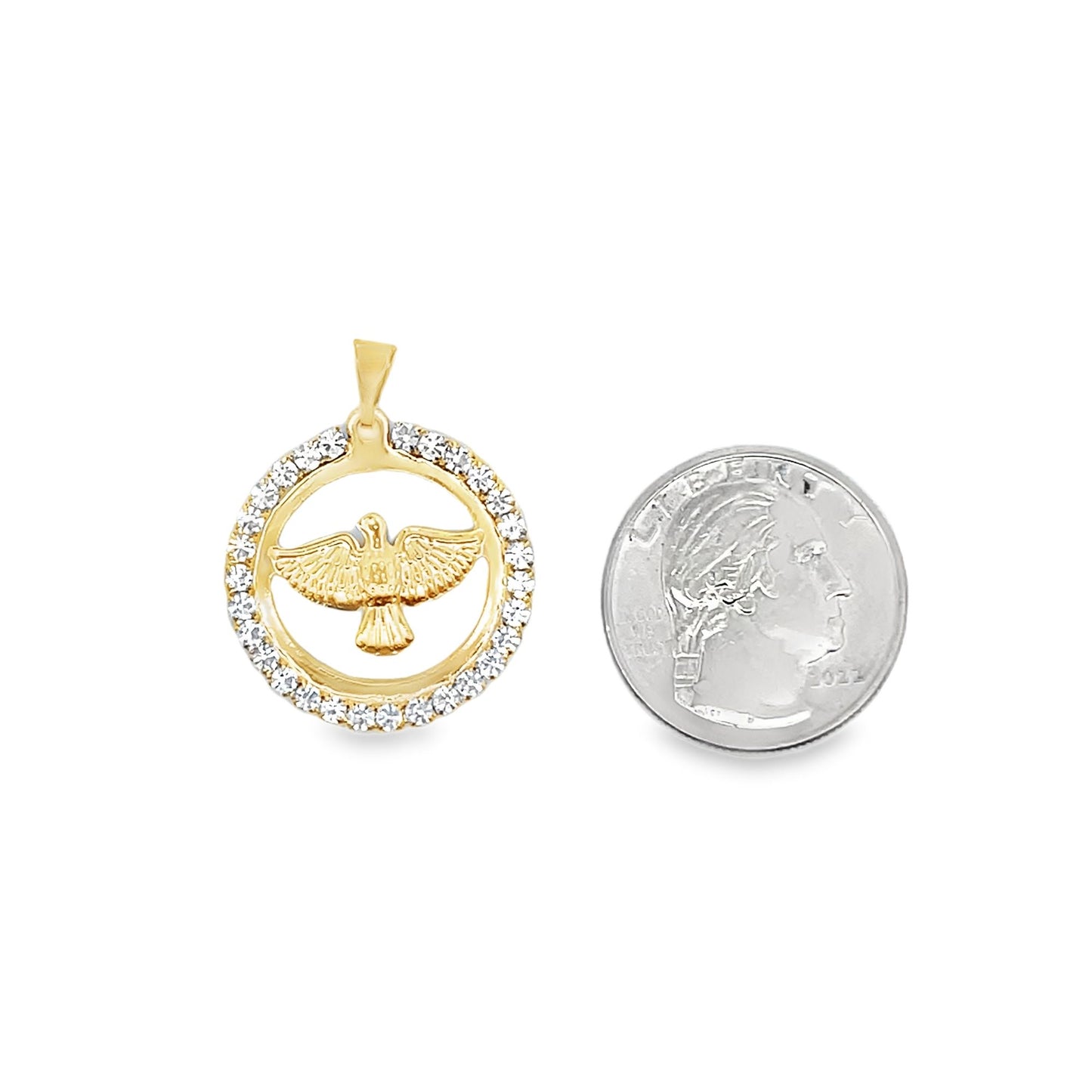 A gold dove pendant featuring a diamond-encrusted circular frame sits next to a US quarter for scale.