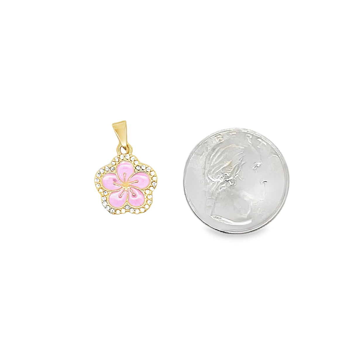 A gold flower pendant featuring pink enamel petals and sparkling CZ stones sits next to a US quarter for scale.