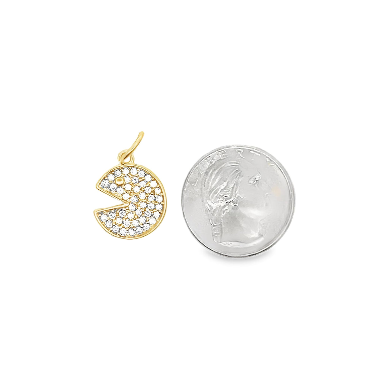 A gold Pac-Man pendant encrusted with sparkling cubic zirconia stones rests next to a US dime for size comparison.