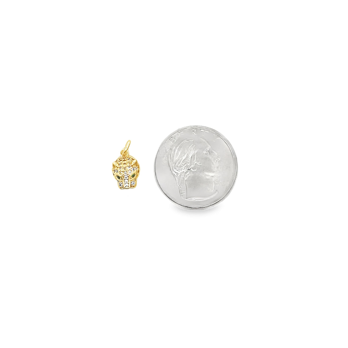 A gold panther pendant rests beside a US quarter to demonstrate its scale.