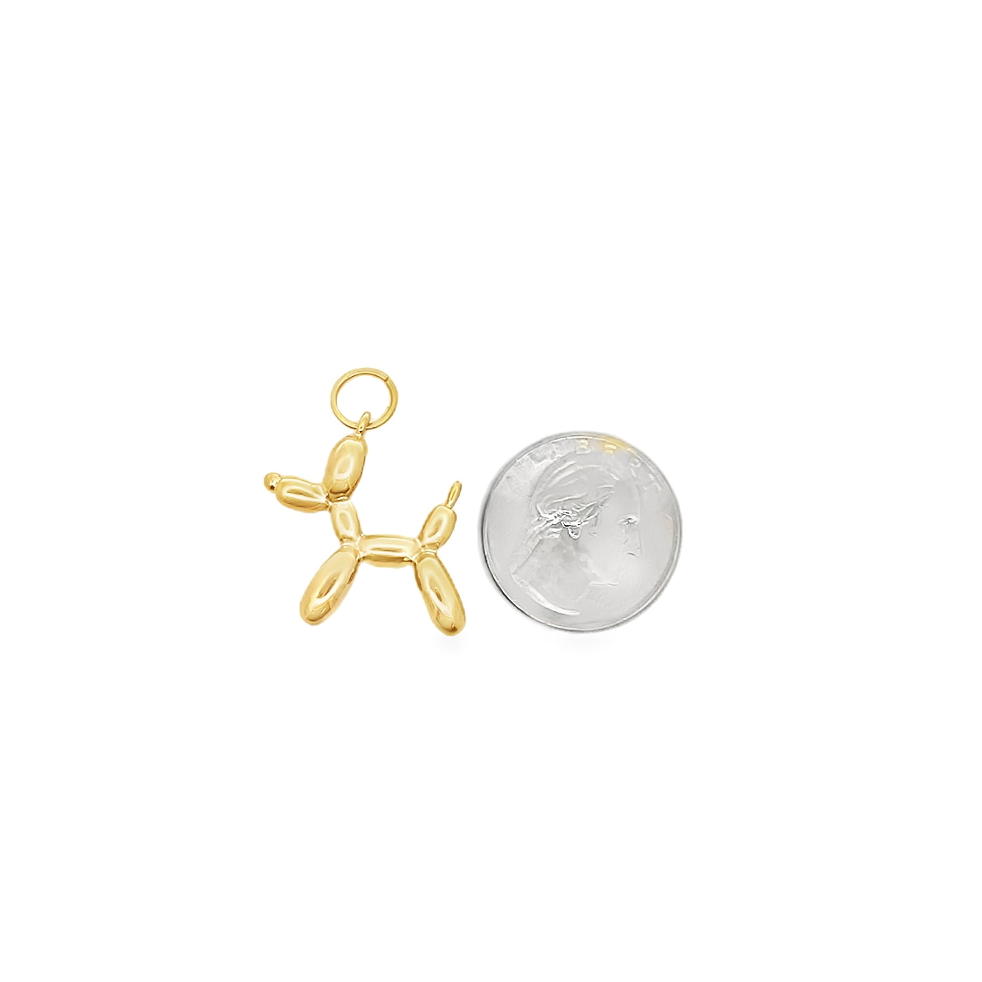 A gold balloon dog charm rests next to a US quarter for size comparison.