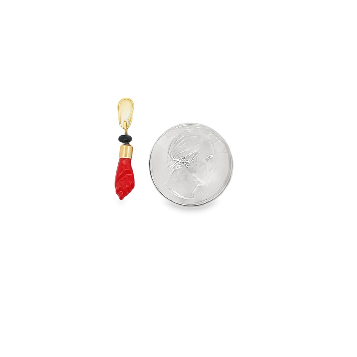 A red coral figa charm pendant stands next to a US quarter coin for scale on a white background.