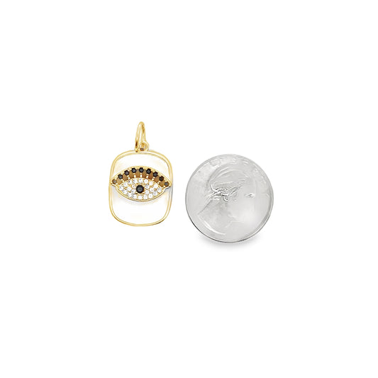A gold evil eye charm pendant rests next to a US dime for size comparison.