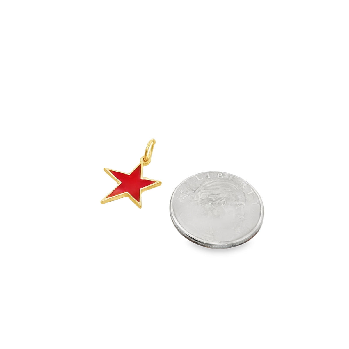 A gold star charm filled with red enamel rests beside a US dime for scale.