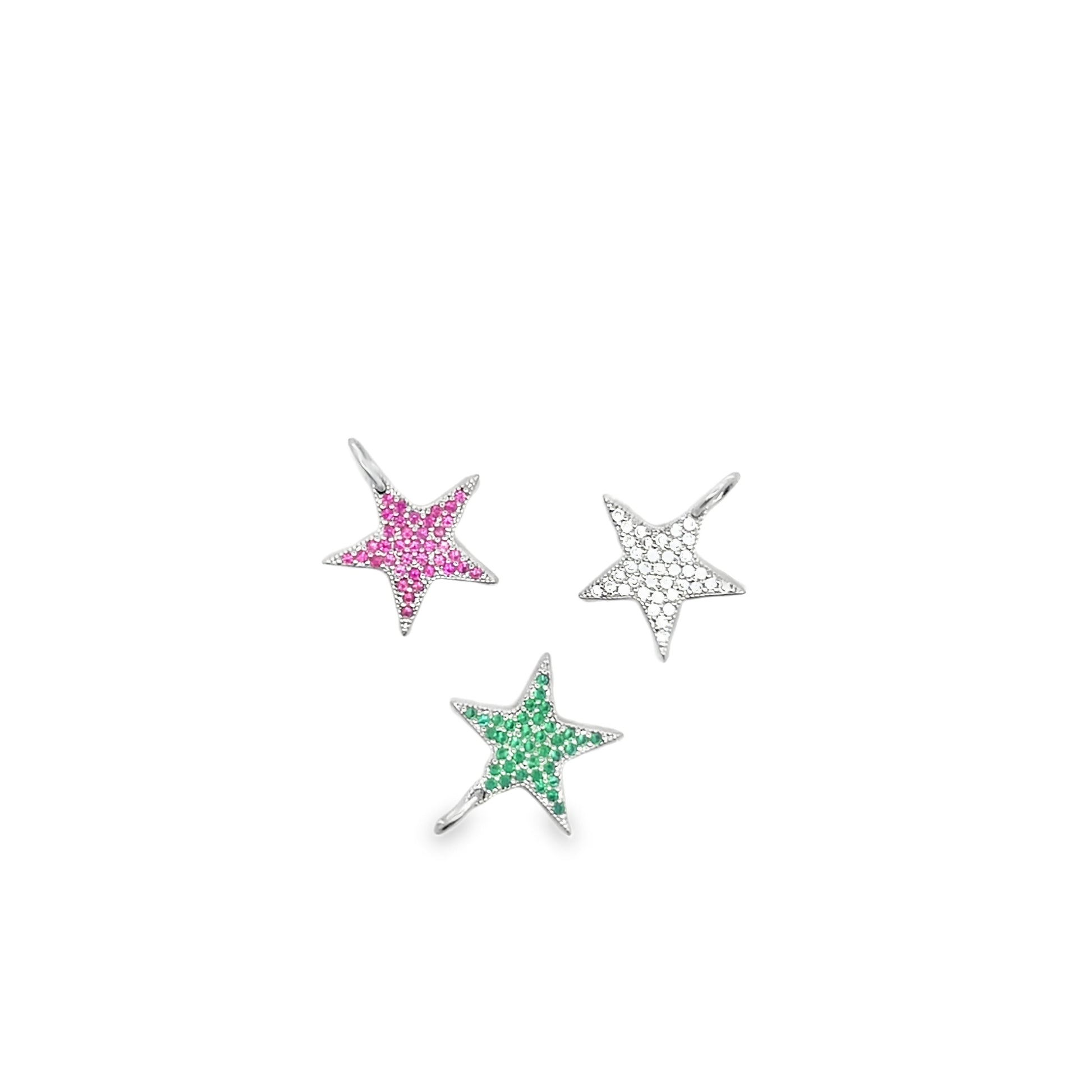 Three star-shaped silver pendants feature pavé settings with pink, green, and white gemstones against a plain white background.