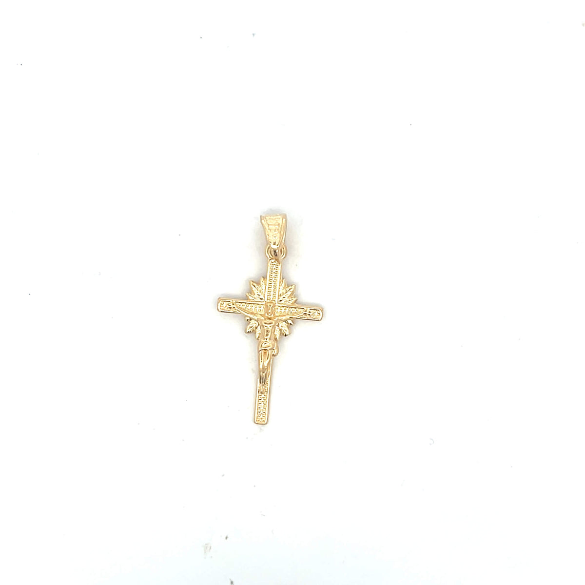 A gold crucifix pendant featuring a detailed depiction of Jesus rests against a plain white background.