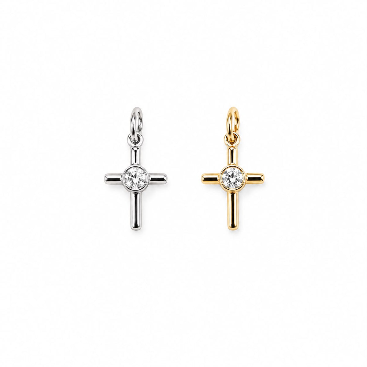 Two diamond cross pendants, one in silver and one in gold, rest side by side on a clean white background.