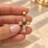 Shop a 18K Gold Filled cross pendant featuring a colorful center stone and sparkling clear CZ accents. Available in multiple stone color options.